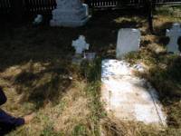 Съборената надгробна плоча и счупен кръст в двора на църквата в Бабадаг